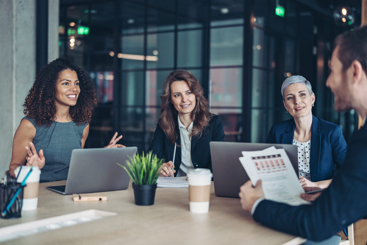 Group of business persons sitting around a table and talking about b2b market research