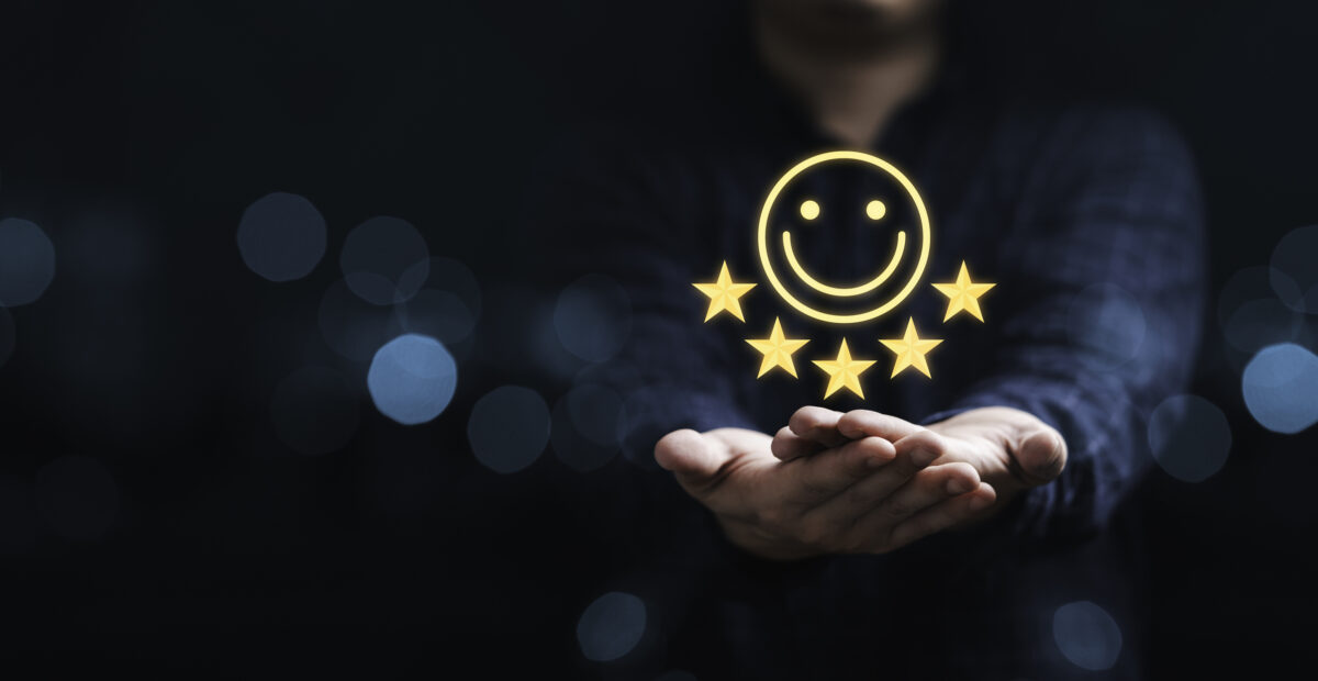 A pair of hands shown with a superimposed smiling face and five stars above it, indicating a positive brand perception.