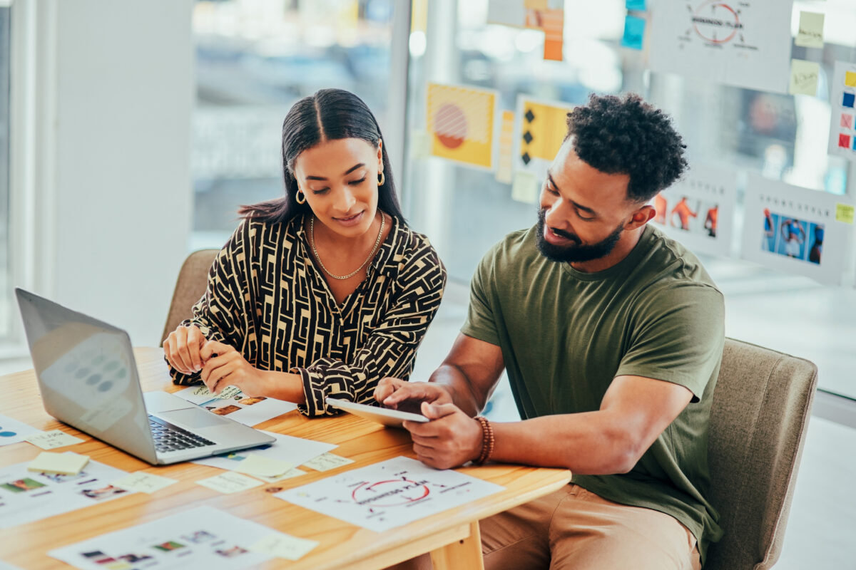 Two colleagues using a software tool to measure brand lift metrics related to a recent campaign.