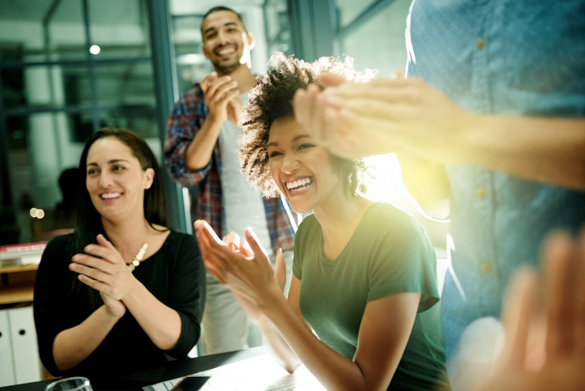 Smiling employee working with a team to develop her company’s brand promise.